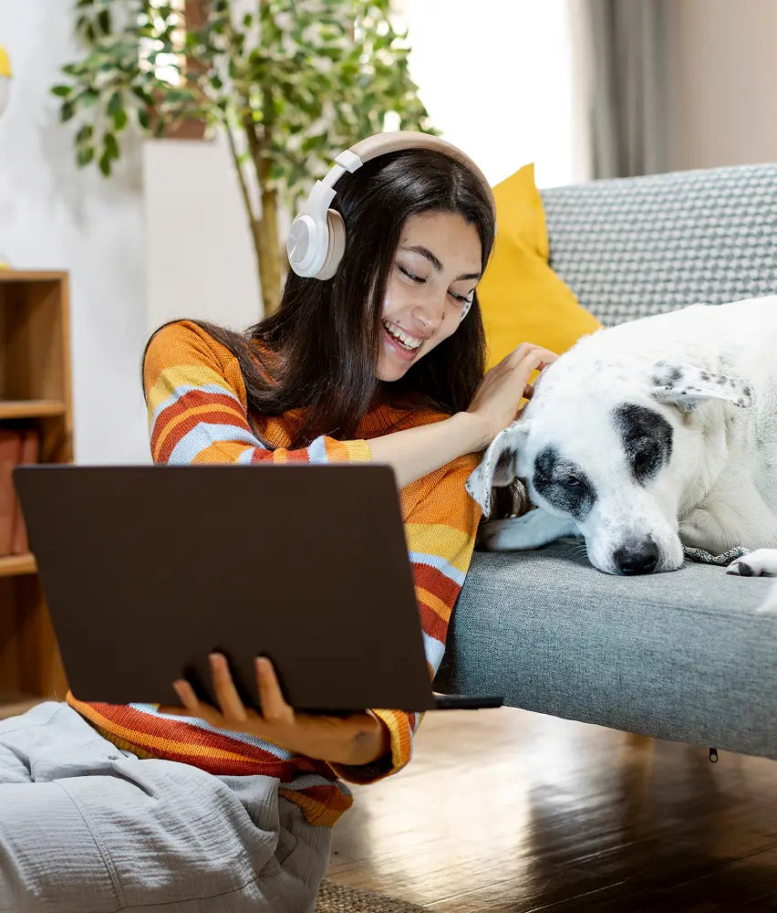 Pet owner on a laptop video call with a Dutch vet, dog beside her